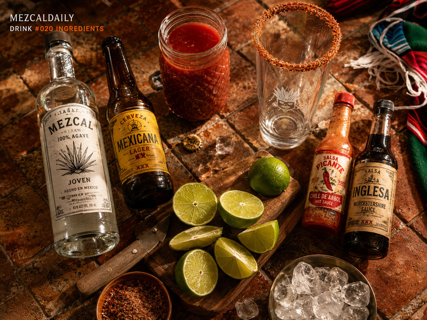 Ingredients and tools for the Mezcal Michelada with mezcal, Mexican lager, lime, hot sauce, Worcestershire sauce, chile salt, tomato mix, ice, and rimmed glass.